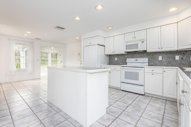 5 Honeysuckle Ln, Scarborough, ME 04074 - kitchen with white appliances, light tile patterned flooring, white cabinets, tasteful backsplash, and a center island