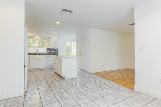 5 Honeysuckle Ln, Scarborough, ME 04074 - kitchen with white appliances, white cabinetry, a kitchen island, decorative backsplash, and light tile patterned floors