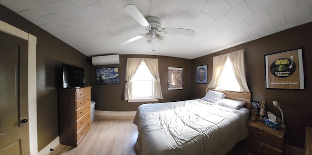 295 Grove St, Bangor, ME 04401 - bedroom featuring a wall mounted AC, multiple windows, light wood finished floors, and baseboards