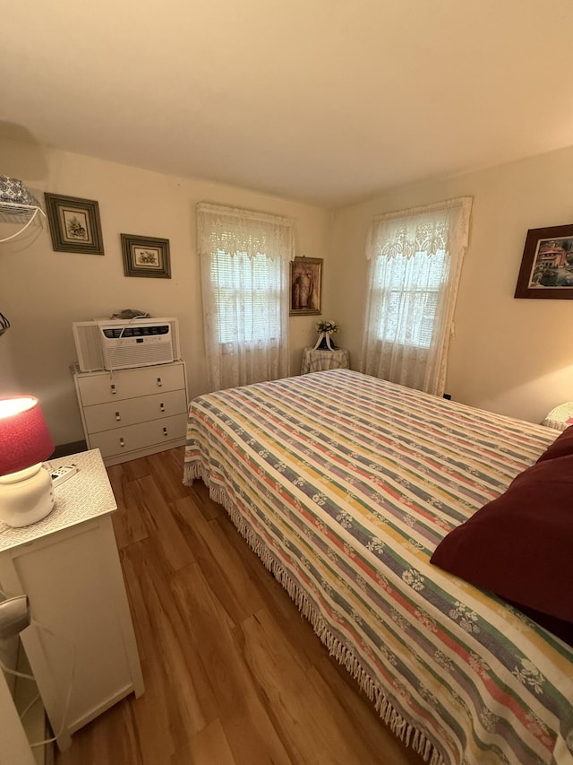 26-28 Acorn Rd, Naples, ME 04055 - bedroom with multiple windows, wood finished floors, and a wall unit AC