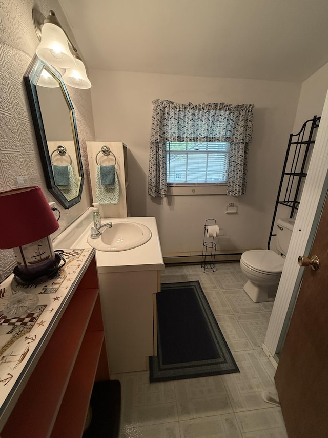26-28 Acorn Rd, Naples, ME 04055 - bathroom featuring toilet, vanity, a baseboard heating unit, and tile patterned floors