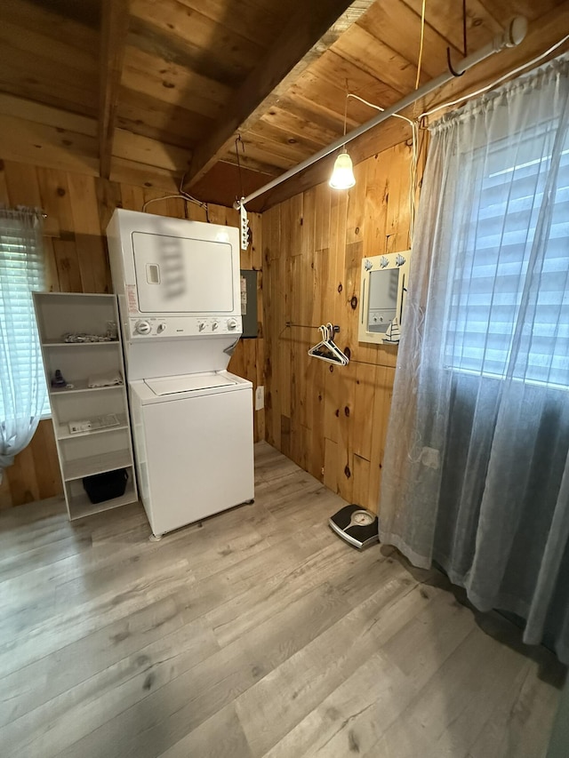 26-28 Acorn Rd, Naples, ME 04055 - laundry room with stacked washer and clothes dryer, wooden walls, wood ceiling, and light wood finished floors
