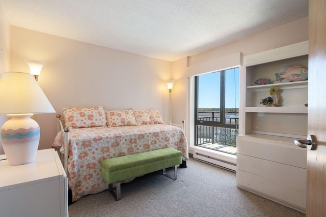 205 E Grand Ave Unit 7E, Old Orchard Beach, ME 04064 - bedroom with a baseboard heating unit, access to outside, light carpet, and a textured ceiling