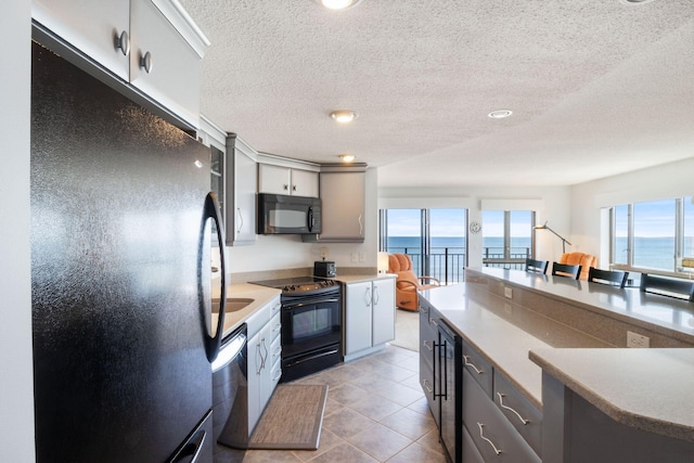 205 E Grand Ave Unit 7E, Old Orchard Beach, ME 04064 - kitchen with black appliances, a textured ceiling, wine cooler, a water view, and light tile patterned floors