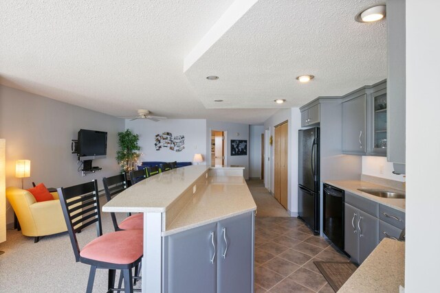 205 E Grand Ave Unit 7E, Old Orchard Beach, ME 04064 - kitchen with black appliances, gray cabinets, a textured ceiling, a kitchen bar, and ceiling fan