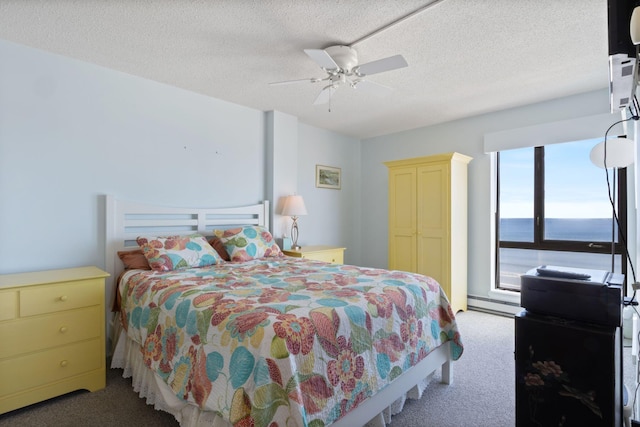 205 E Grand Ave Unit 7E, Old Orchard Beach, ME 04064 - carpeted bedroom featuring a baseboard heating unit, a textured ceiling, and a ceiling fan