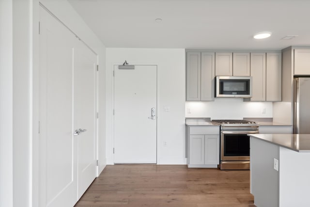 218 Washington Ave Unit 309, Portland, ME 04101 - kitchen featuring appliances with stainless steel finishes, gray cabinets, light wood-style flooring, baseboards, and light countertops