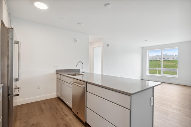 218 Washington Ave Unit 309, Portland, ME 04101 - kitchen with a sink, a peninsula, appliances with stainless steel finishes, light wood-style floors, and open floor plan