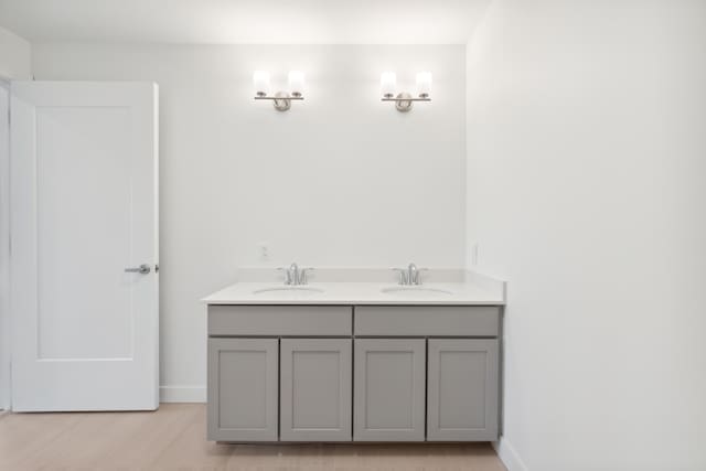 218 Washington Ave Unit 309, Portland, ME 04101 - bathroom with wood finished floors, double vanity, and baseboards