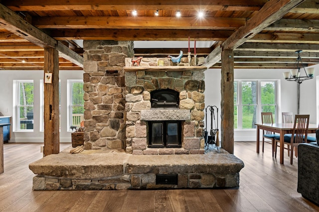 6 Bluebird Way, Kennebunk, ME 04043 - living area featuring wooden ceiling with exposed beams, a stone fireplace, a chandelier, wood-type flooring, and healthy amount of natural light