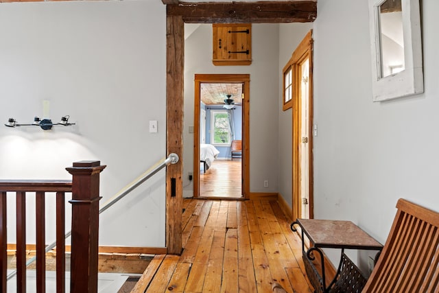 6 Bluebird Way, Kennebunk, ME 04043 - hall with light wood finished floors, beam ceiling, baseboards, and an upstairs landing