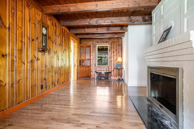 23 Paul St, South Berwick, ME 03908 - living room with wood ceiling with exposed beams, wood finished floors, wood walls, and a glass covered fireplace