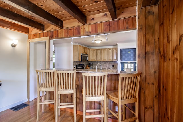 23 Paul St, South Berwick, ME 03908 - kitchen featuring stainless steel microwave, track lighting, wood finished floors, baseboards, and wooden ceiling with exposed beams