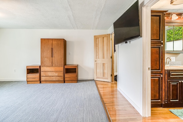 23 Paul St, South Berwick, ME 03908 - unfurnished bedroom with light wood-style flooring, baseboards, a textured ceiling, and a sink