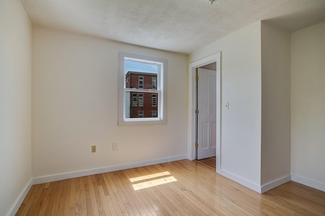 23 Paul St, South Berwick, ME 03908 - empty room featuring wood-type flooring, baseboards, and a textured ceiling