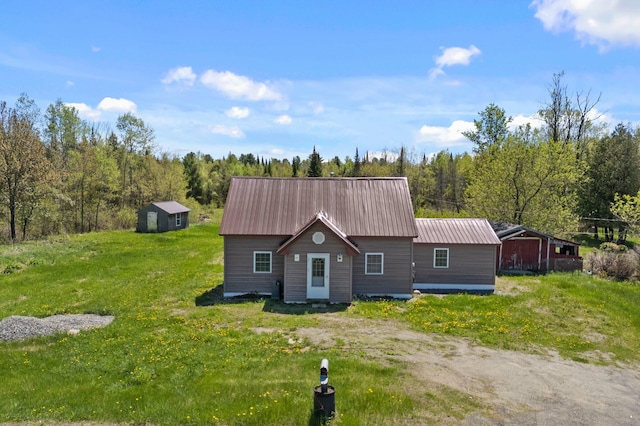 rustic home featuring metal roof and a front lawn
