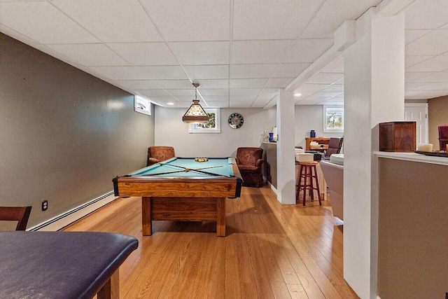 game room featuring a baseboard radiator, light wood-type flooring, a drop ceiling, healthy amount of natural light, and billiards table