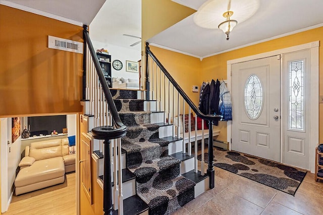 entryway featuring ornamental molding and stairs