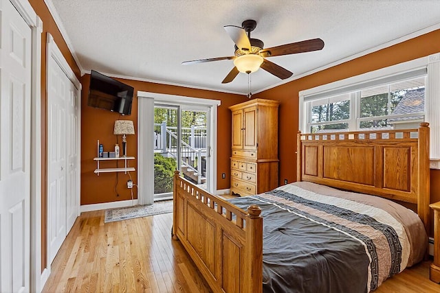 bedroom featuring access to outside, light wood-style flooring, baseboards, a textured ceiling, and ornamental molding