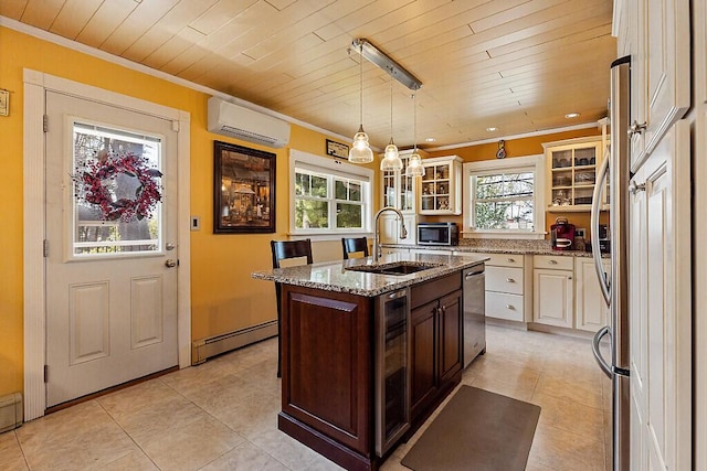 kitchen featuring a sink, an AC wall unit, a baseboard heating unit, stainless steel appliances, and an island with sink