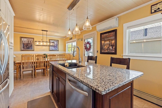 kitchen with a wall mounted air conditioner, a sink, appliances with stainless steel finishes, a baseboard radiator, and light tile patterned floors