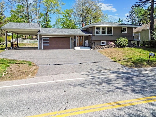 tri-level home with asphalt driveway, a garage, a carport, and a chimney