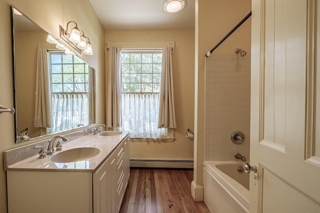 full bath with a baseboard heating unit, wood finished floors, shower / washtub combination, and double vanity
