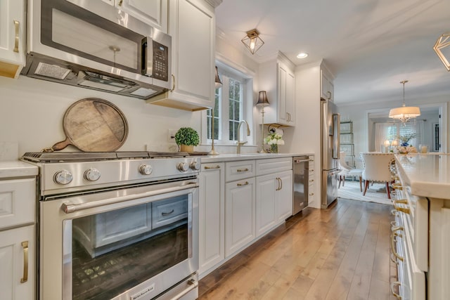 4 Brown Hill Ln, Scarborough, ME 04074 - kitchen featuring high quality appliances, a sink, light countertops, white cabinets, and ornamental molding