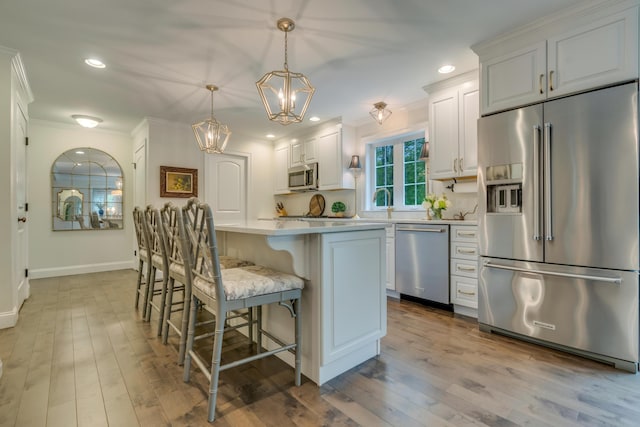 4 Brown Hill Ln, Scarborough, ME 04074 - kitchen with stainless steel appliances, a chandelier, ornamental molding, a breakfast bar area, and a center island