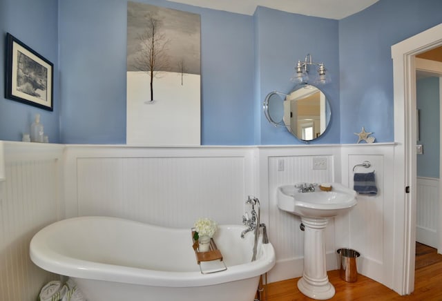 131 N St, Bath, ME 04530 - full bath with wainscoting, a decorative wall, a soaking tub, and wood finished floors