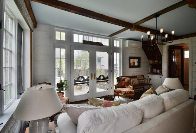 131 N St, Bath, ME 04530 - living room featuring french doors, beam ceiling, a chandelier, wooden walls, and a wall unit AC