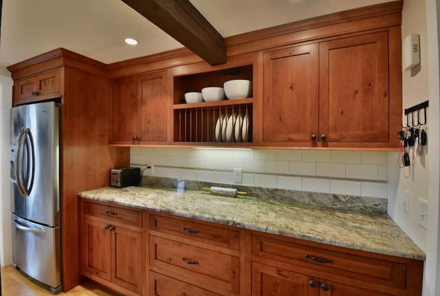 131 N St, Bath, ME 04530 - kitchen featuring stainless steel refrigerator with ice dispenser, brown cabinets, beamed ceiling, backsplash, and light stone counters