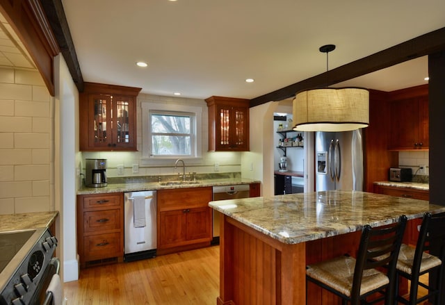 131 N St, Bath, ME 04530 - kitchen featuring a sink, stainless steel appliances, backsplash, light wood-style floors, and a breakfast bar area