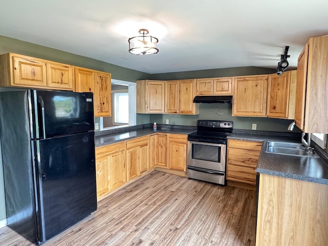 1575 Main St, Mapleton, ME 04757 - kitchen featuring freestanding refrigerator, stainless steel range with electric cooktop, under cabinet range hood, dark countertops, and light wood finished floors