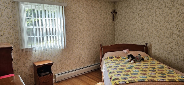 645 Kennebec St, Rumford, ME 04276 - bedroom featuring a baseboard radiator, multiple windows, wood finished floors, and wallpapered walls