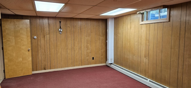 645 Kennebec St, Rumford, ME 04276 - spare room featuring baseboard heating, carpet floors, wooden walls, and a drop ceiling