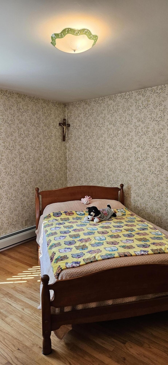 645 Kennebec St, Rumford, ME 04276 - bedroom featuring a baseboard radiator, wallpapered walls, and wood finished floors