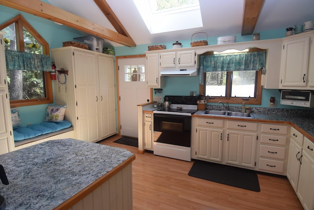 kitchen with electric range, a sink, a skylight, under cabinet range hood, and light wood-style floors