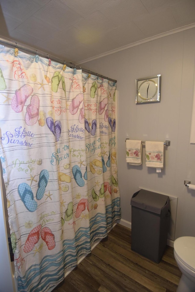 bathroom with ornamental molding, wood finished floors, a shower with curtain, and toilet