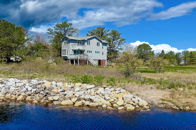 back of property with stairs and a water view