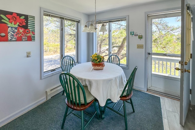 dining room with a baseboard radiator, a chandelier, healthy amount of natural light, and baseboards