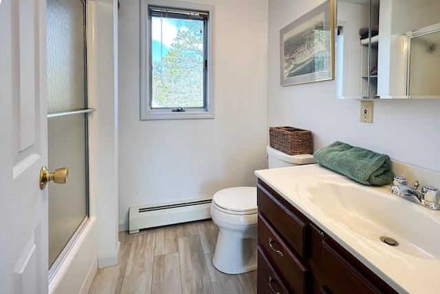 full bath featuring a baseboard heating unit, toilet, vanity, wood finished floors, and enclosed tub / shower combo