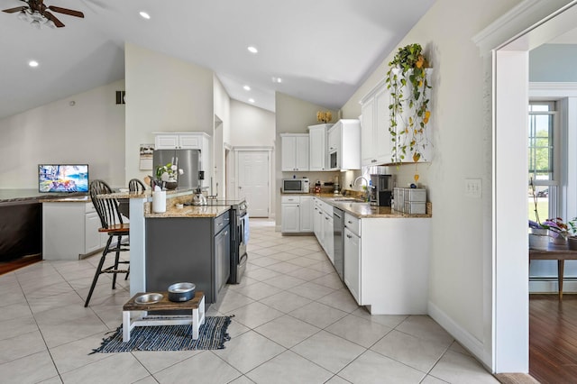 29 Gabriels Way, Turner, ME 04282 - kitchen with stainless steel appliances, a sink, white cabinets, a ceiling fan, and a kitchen breakfast bar