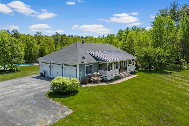 29 Gabriels Way, Turner, ME 04282 - view of front of home featuring a porch, asphalt driveway, a front lawn, a garage, and a view of trees
