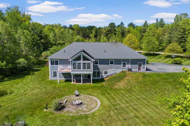 29 Gabriels Way, Turner, ME 04282 - back of house with a fire pit, a wooden deck, a lawn, a forest view, and a patio area
