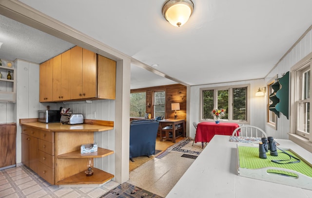 16 Columbia Ave, Tremont, ME 04612 - kitchen featuring open shelves, stainless steel microwave, light countertops, light floors, and wood walls