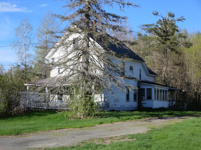view of home's exterior featuring a sunroom and a yard