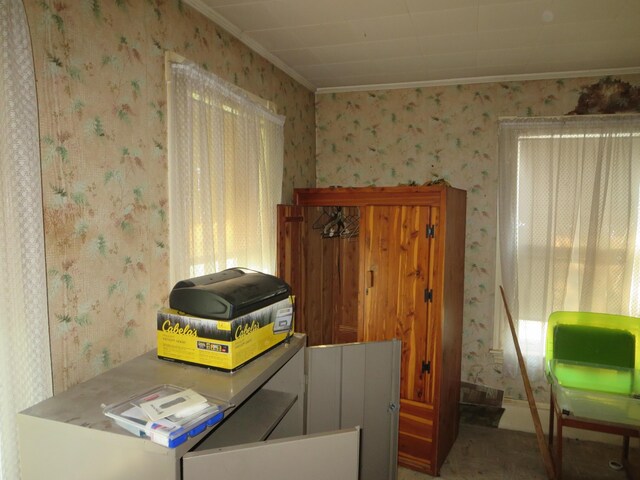 office space with wallpapered walls and ornamental molding