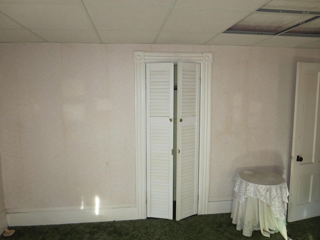 carpeted bedroom featuring a paneled ceiling and baseboards