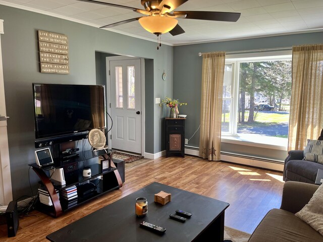 5 Mayo St, Caribou, ME 04736 - living room featuring baseboard heating, plenty of natural light, ceiling fan, wood finished floors, and ornamental molding